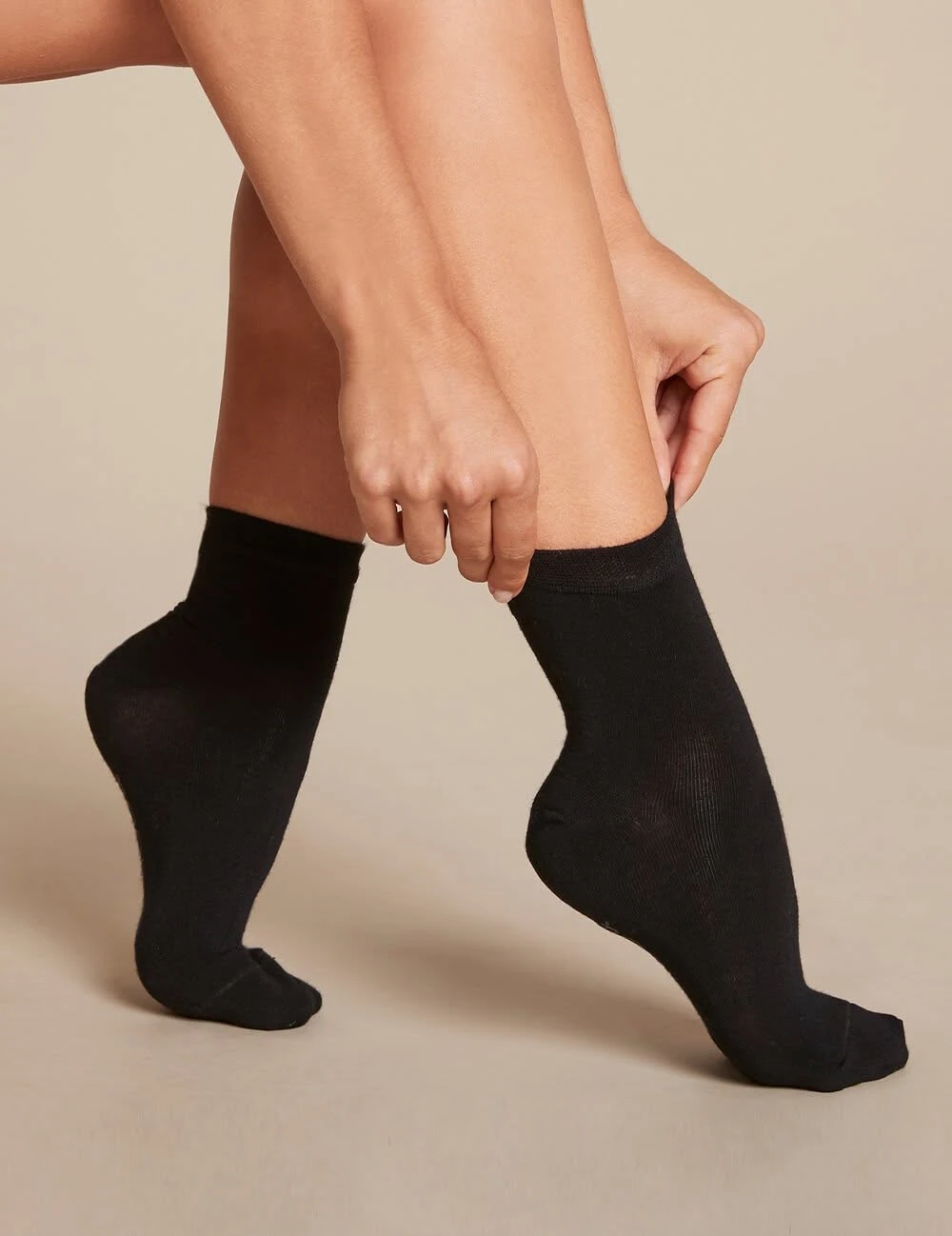 Bambui bamboo socks: product photography of black ankle socks being pulled on