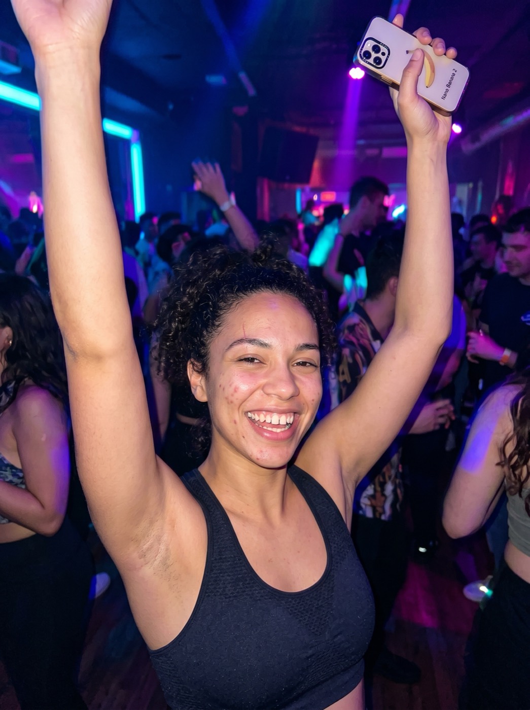 AI UGC creator dancing in a neon-lit nightclub, arms up, phone in hand, candid party energy